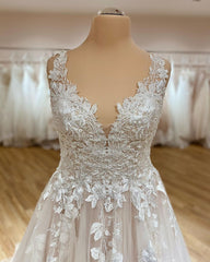 Elegant Deep V-neck A-Line Wedding Gown with Spaghetti Straps, Ruffles, and Lace Appliques on Tulle
