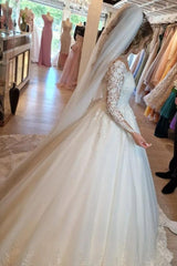 Elegant white lace wedding dress featuring a V-neck and long sleeves in an A-line silhouette