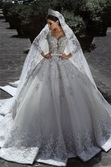 Wedding Dress with Long Sleeves, Beads, and Lace Appliques in a Ball Gown Style