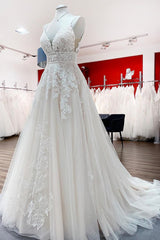 V-neck sleeveless A-line tulle wedding dress with backless design, lace appliques, and ruffles