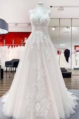 V-neck sleeveless A-line tulle wedding dress with backless design, lace appliques, and ruffles